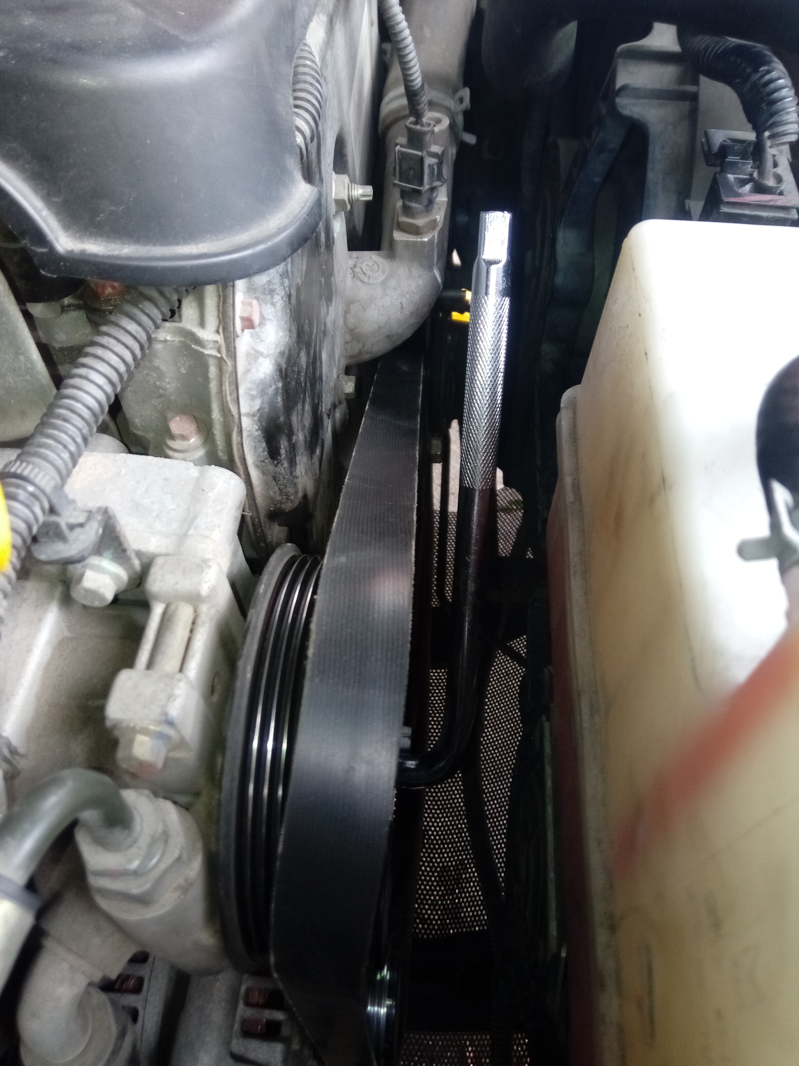 新的单向轮用工具加扳手拧好，盖好单项轮上面的塑料盖板，然后把新的皮带换上去，按之前原厂的样子装上去就 ...