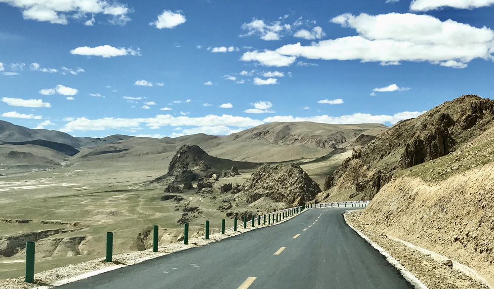 奔驰在省道S205上。车机欢快地唱着，“大大的太阳，温暖着大高原！”